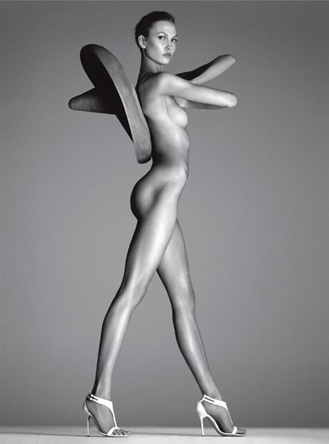 Černobílá fotografie nahé ženy se sombrerem na zádech